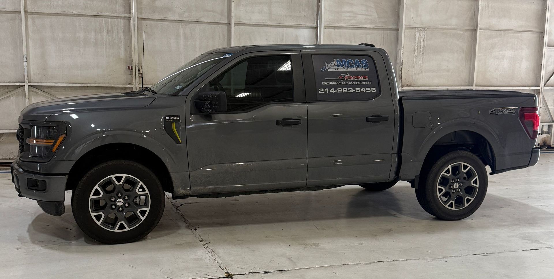 A gray ford f150 truck is parked in a garage.