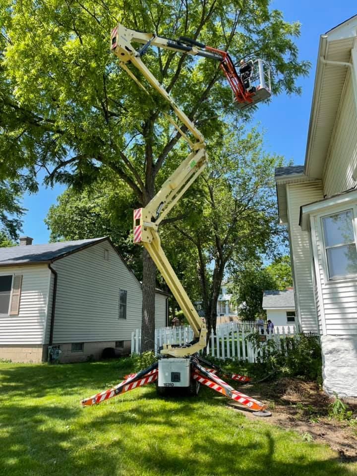 A crane is sitting in front of a house in a yard.