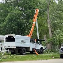 A white truck with a crane attached to the back is parked in front of a house.