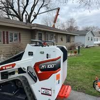 A bobcat mt 100 is parked in front of a house.