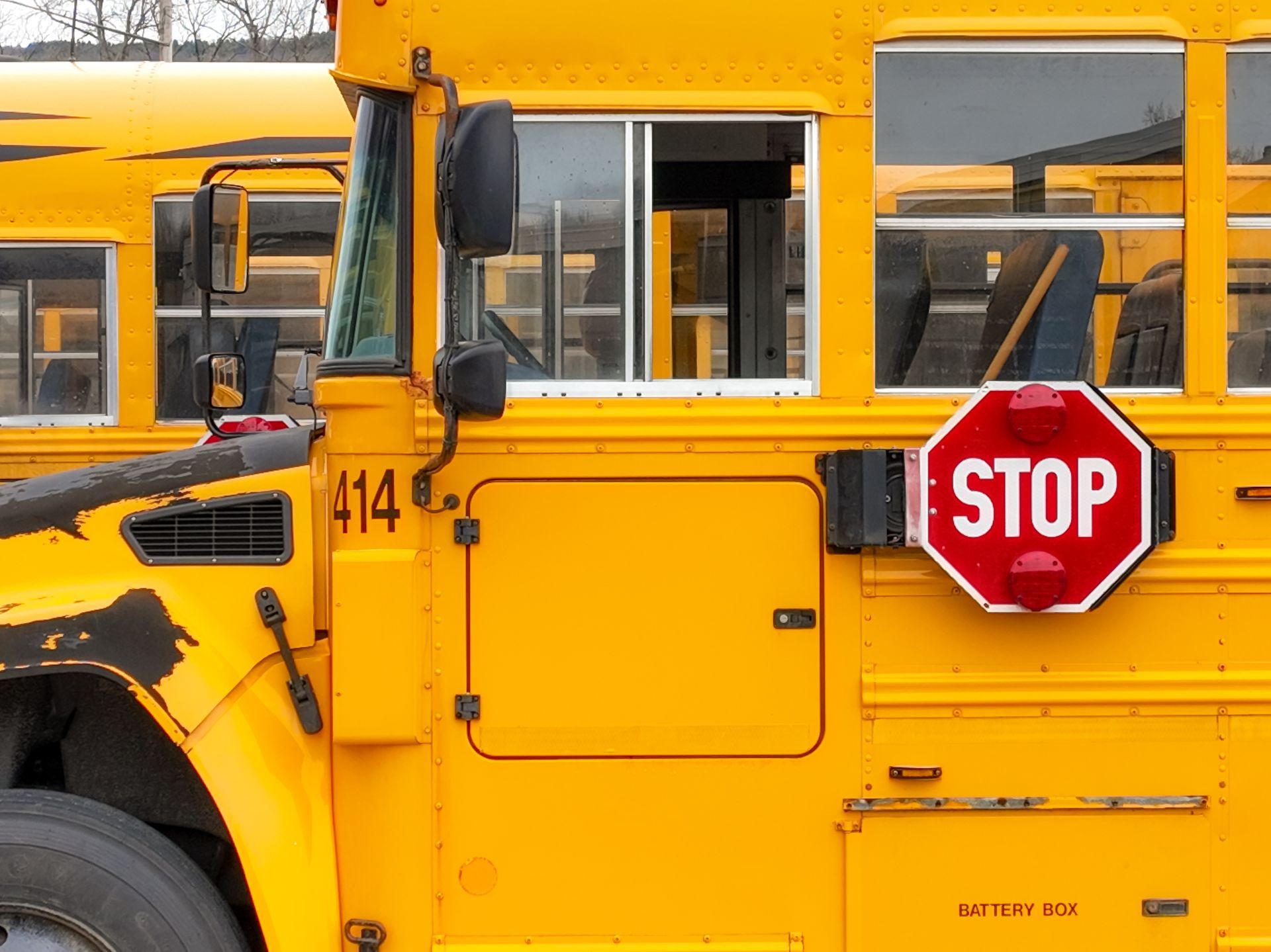 Yellow school bus with door open, stop sign extended.
