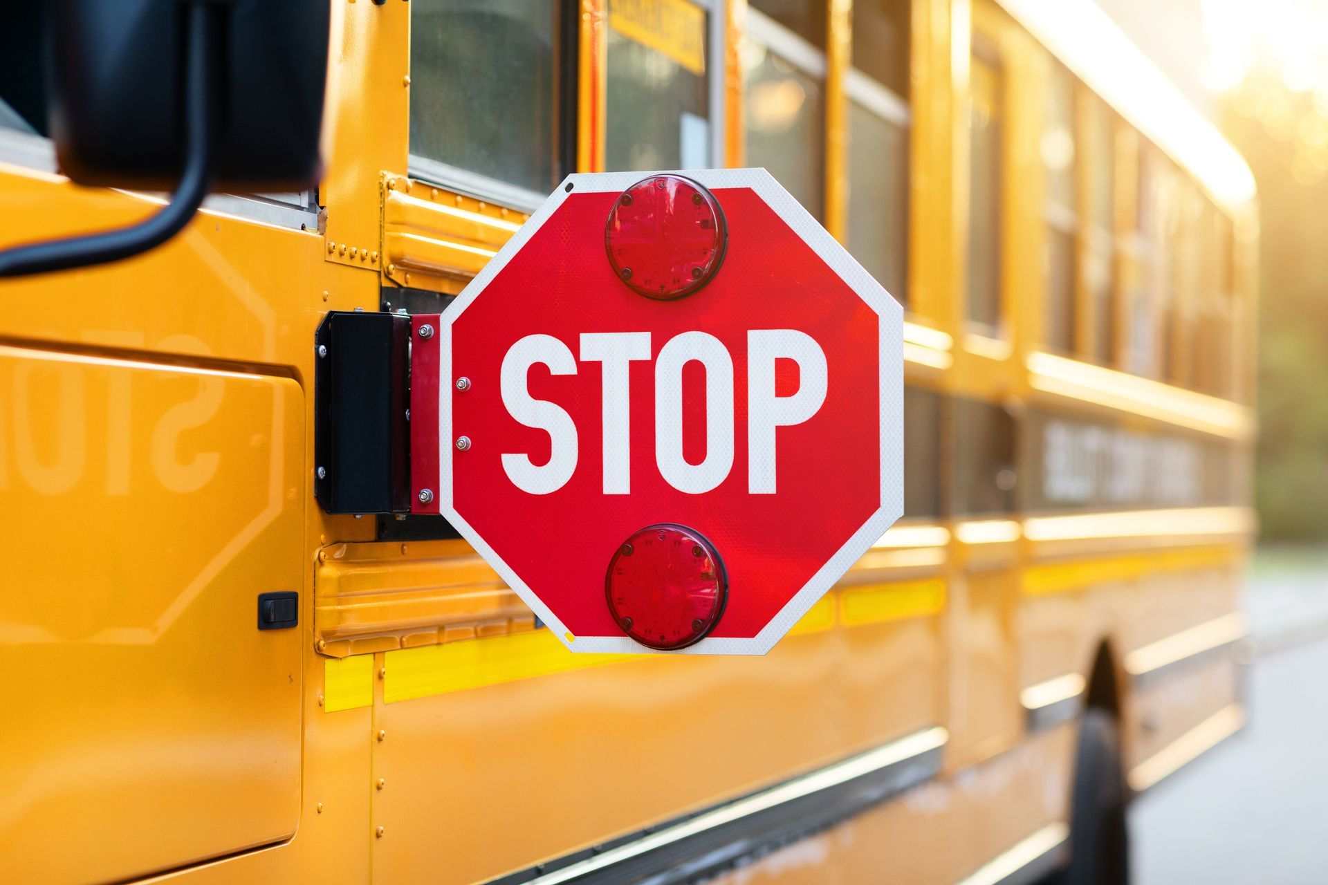 Yellow school bus with extended red STOP sign.