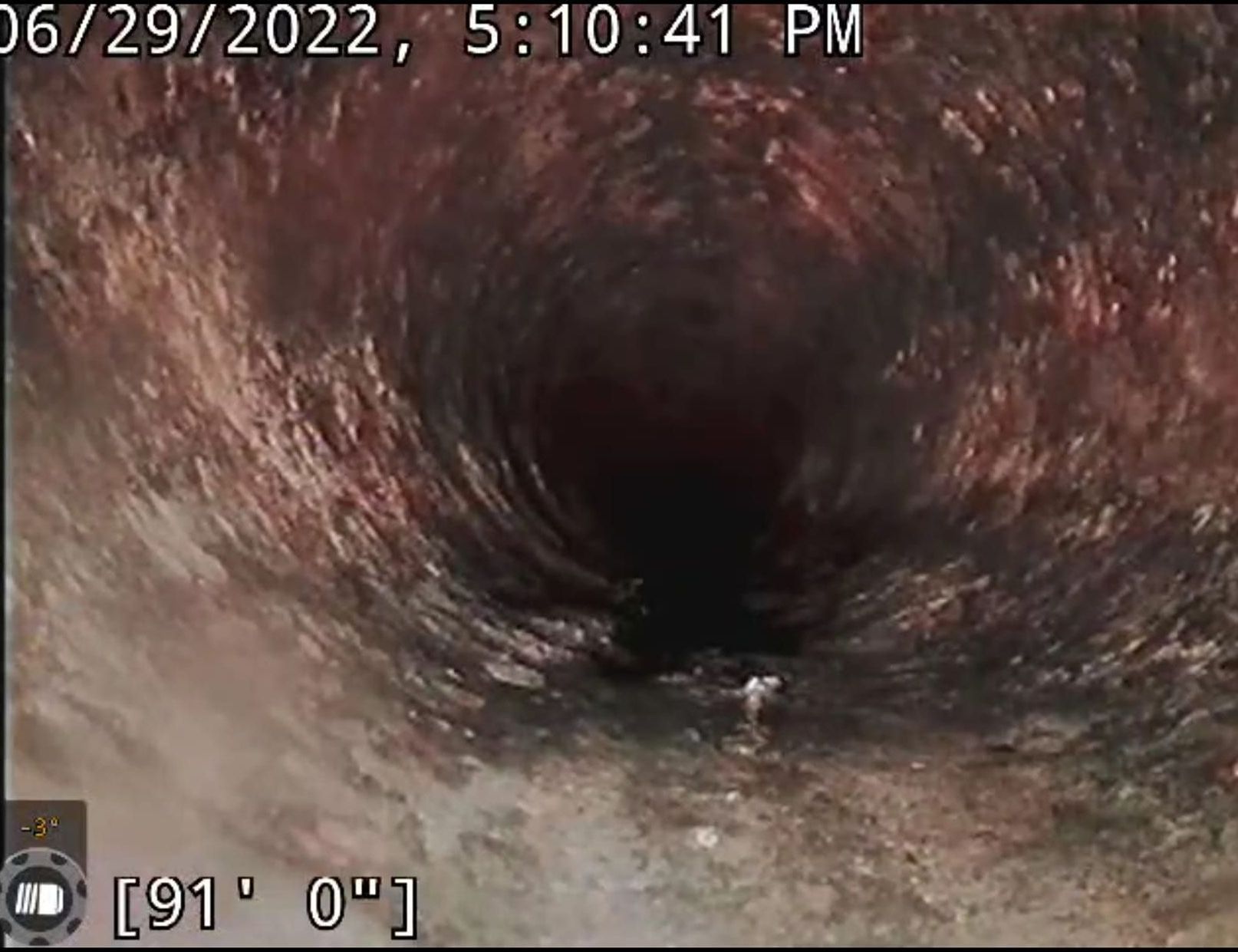 A camera is taking a picture of a hole in a pipe.