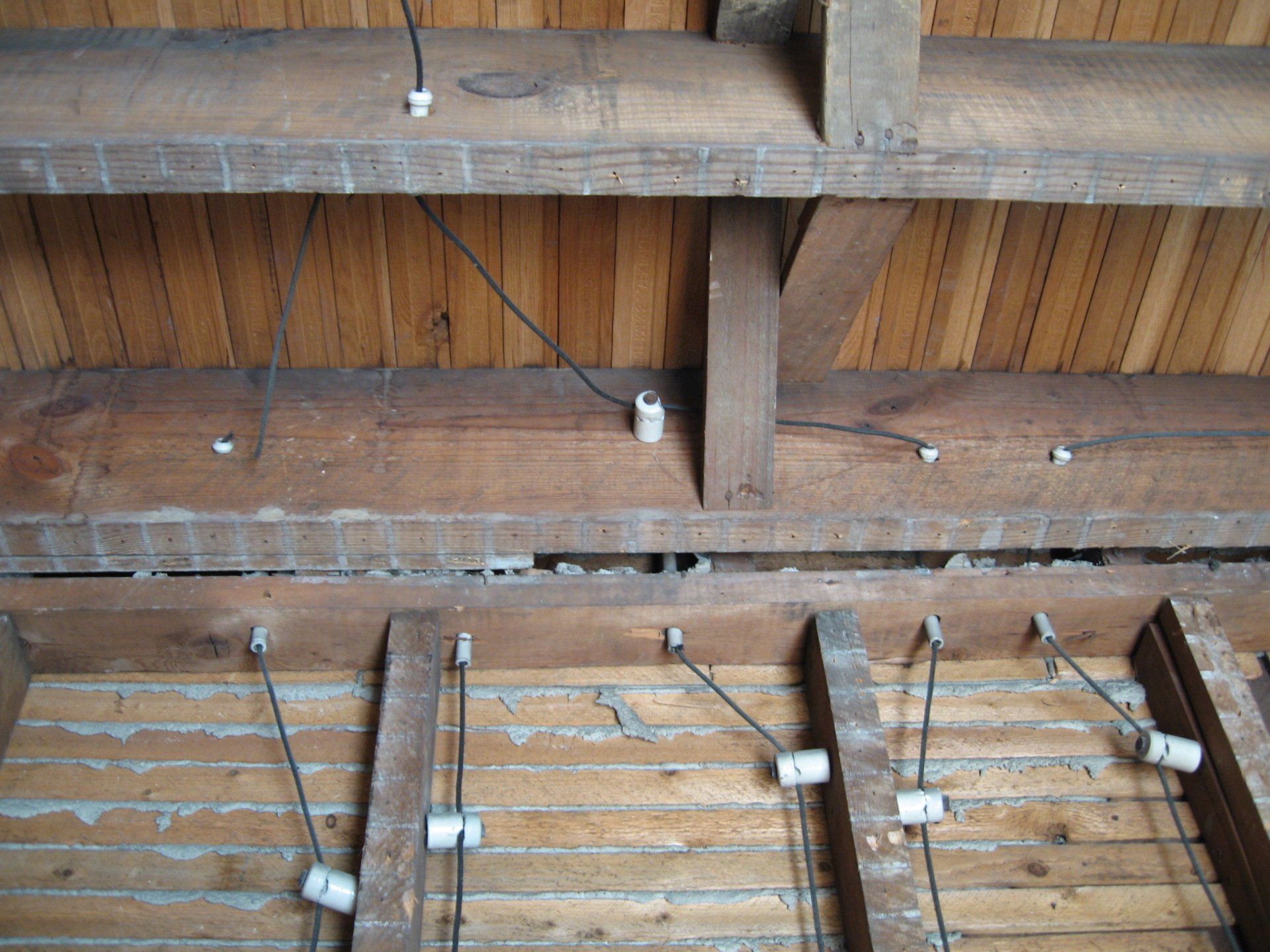 A wooden ceiling with wires hanging from it