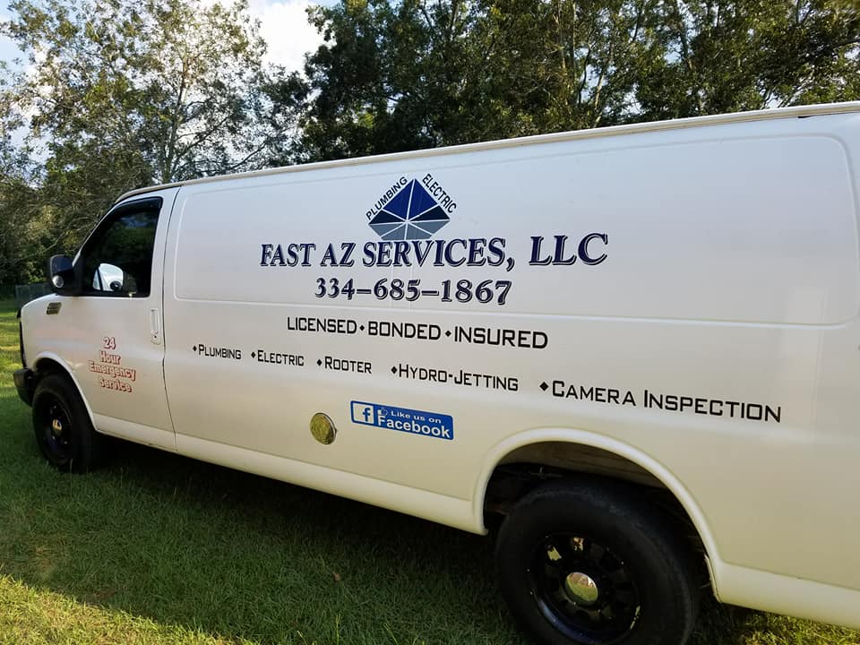 A white van from fast az services llc is parked in the grass
