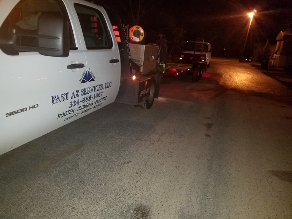 A white truck is parked on the side of the road at night.