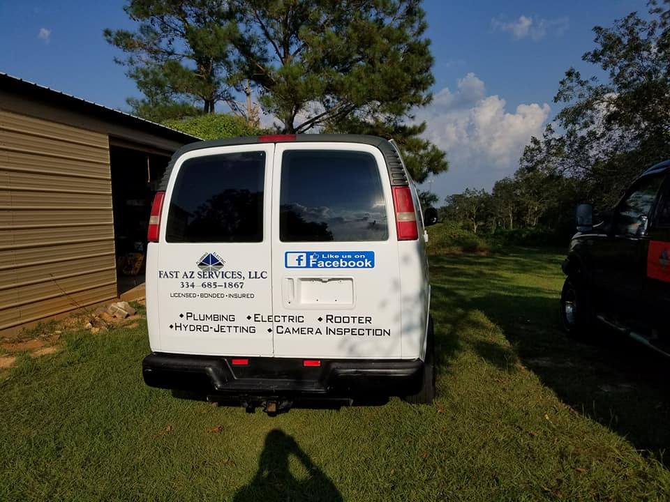 A white van is parked in a grassy field