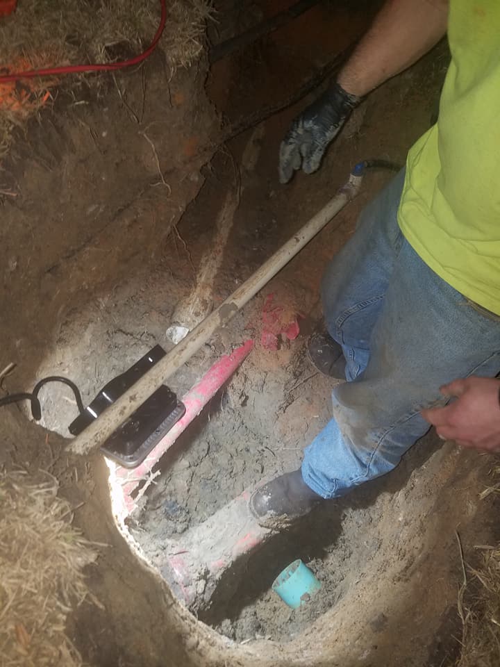 A man is digging a hole in the ground with a shovel.
