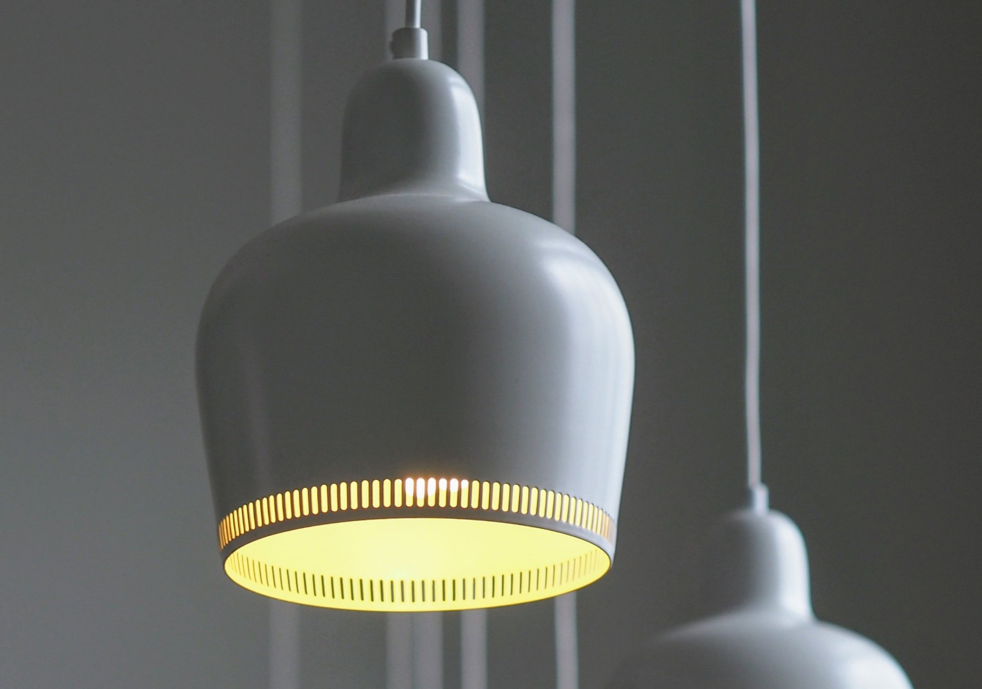 A white lamp with a yellow shade is hanging from the ceiling