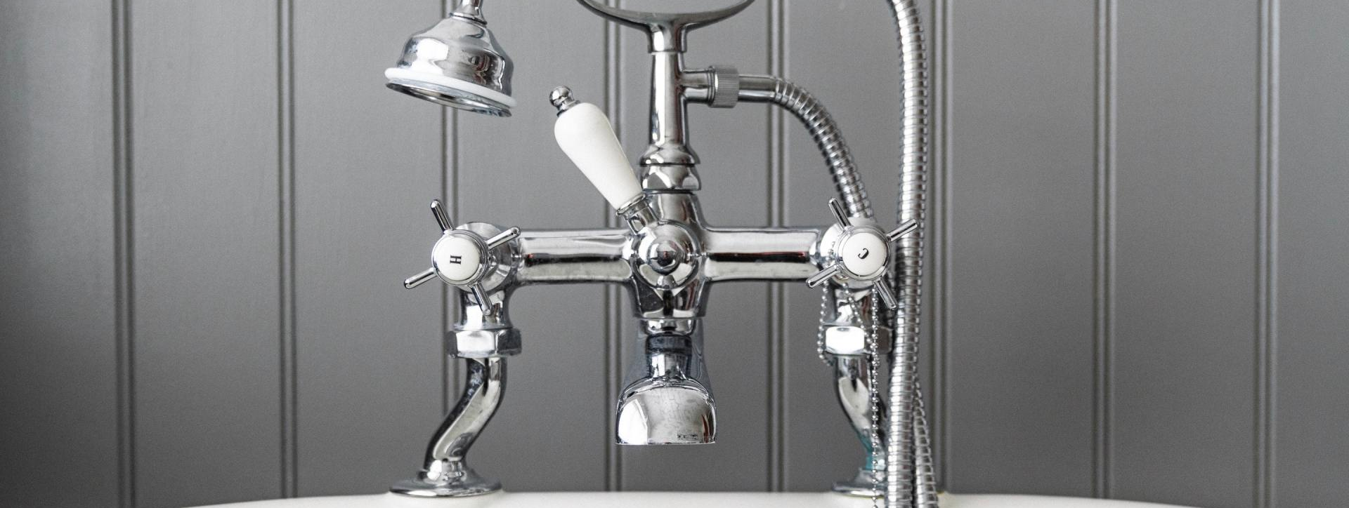 A bathtub faucet with a shower head attached to it.