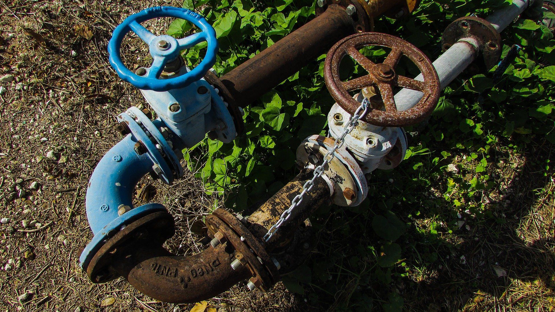 A couple of pipes with blue and white valves on them