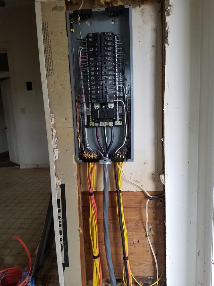 A electrical panel is being installed on a wall in a house.