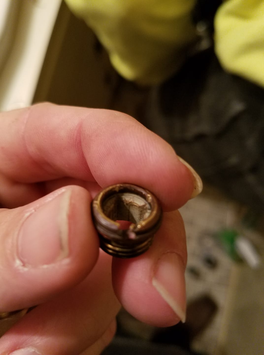 A person is holding a small piece of metal in their hand