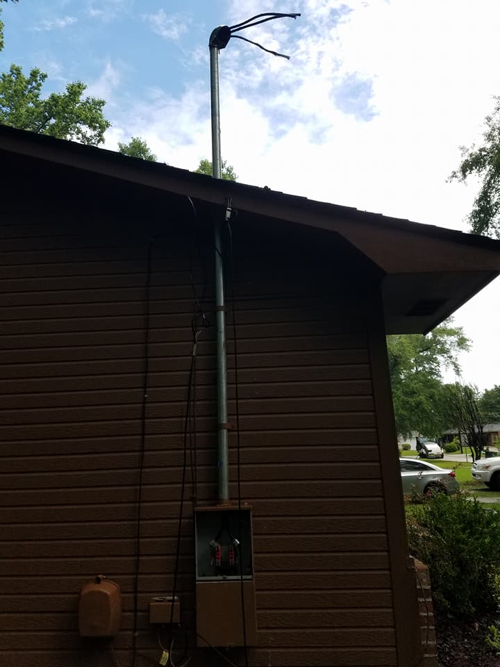 A brown house with a metal pipe coming out of the roof.