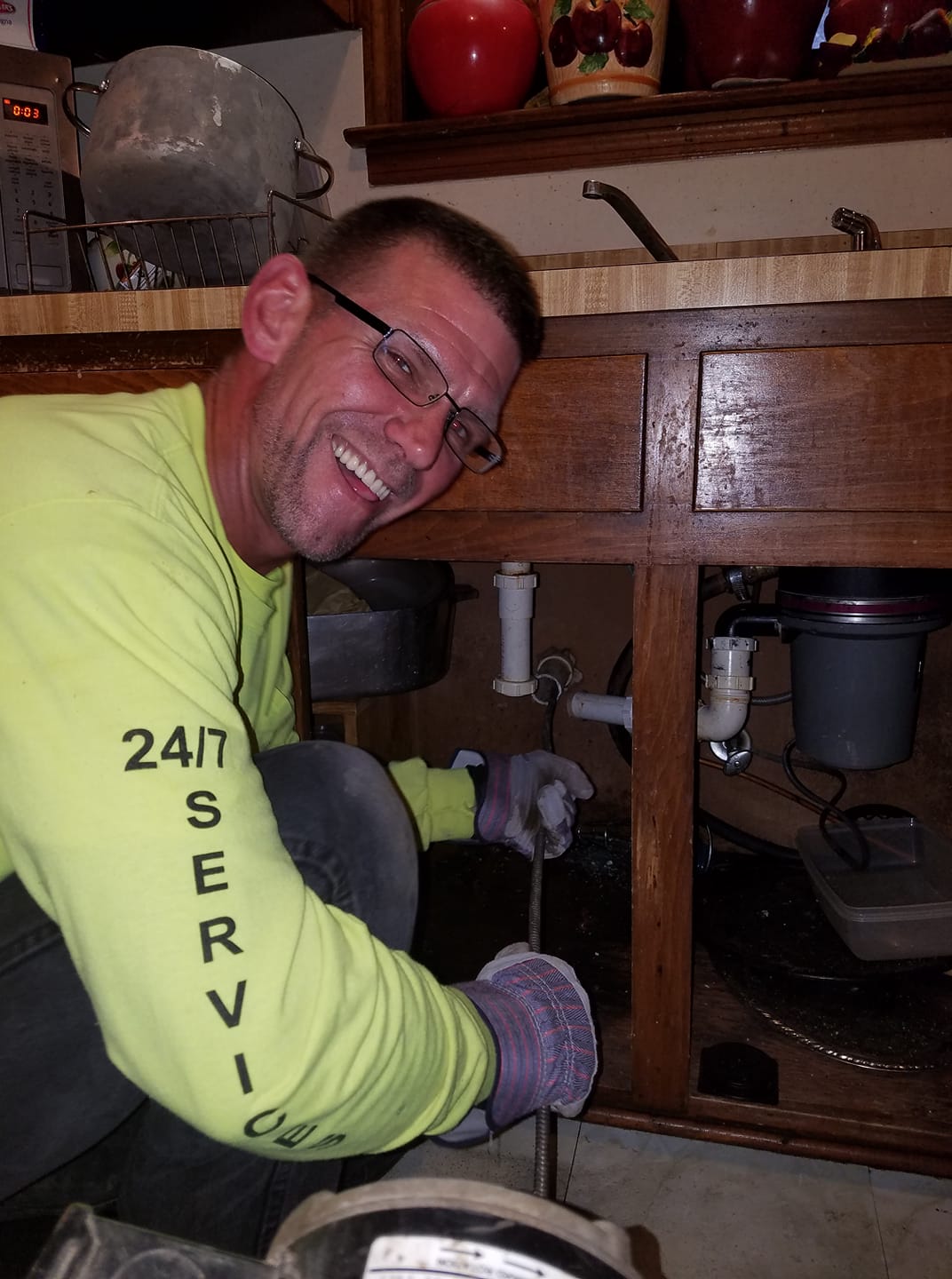 A man wearing a yellow shirt that says 24/7 service