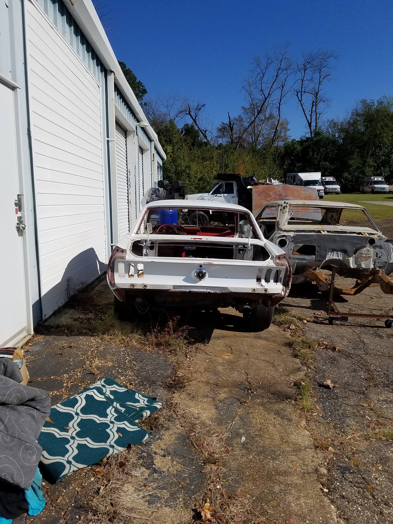 A white car is parked in front of a garage.