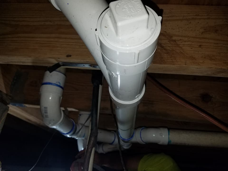 A bunch of white pipes are hanging from the ceiling