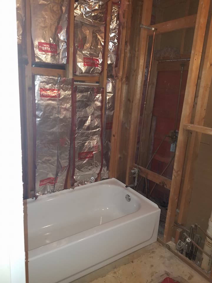 A bathtub is sitting in a bathroom under construction.