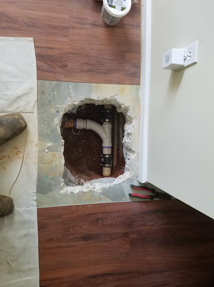 A hole in the floor with a pipe coming out of it.