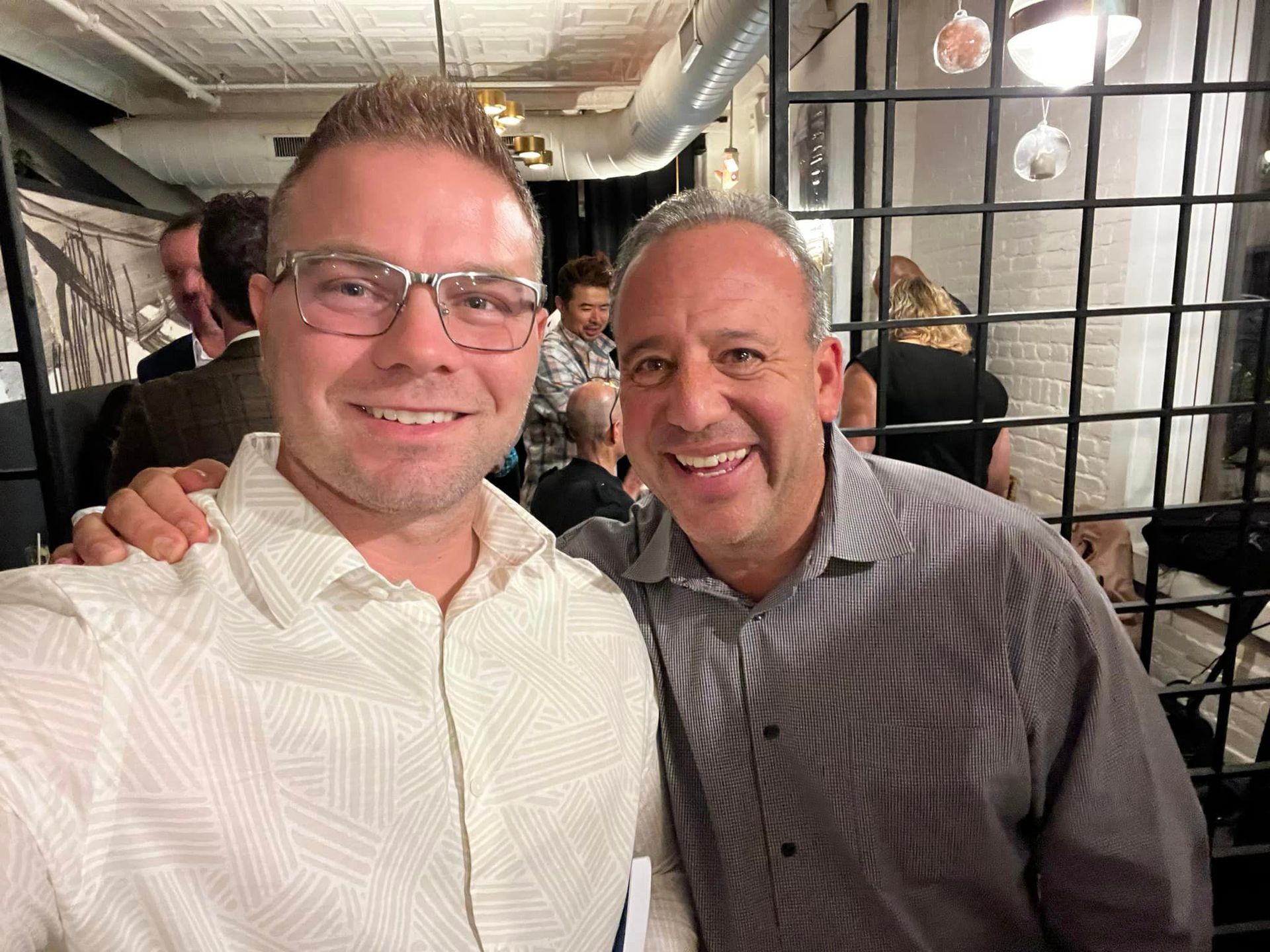 Two men are posing for a picture together in a restaurant.