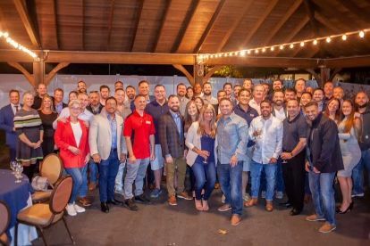 A group of people are posing for a picture in front of a building.