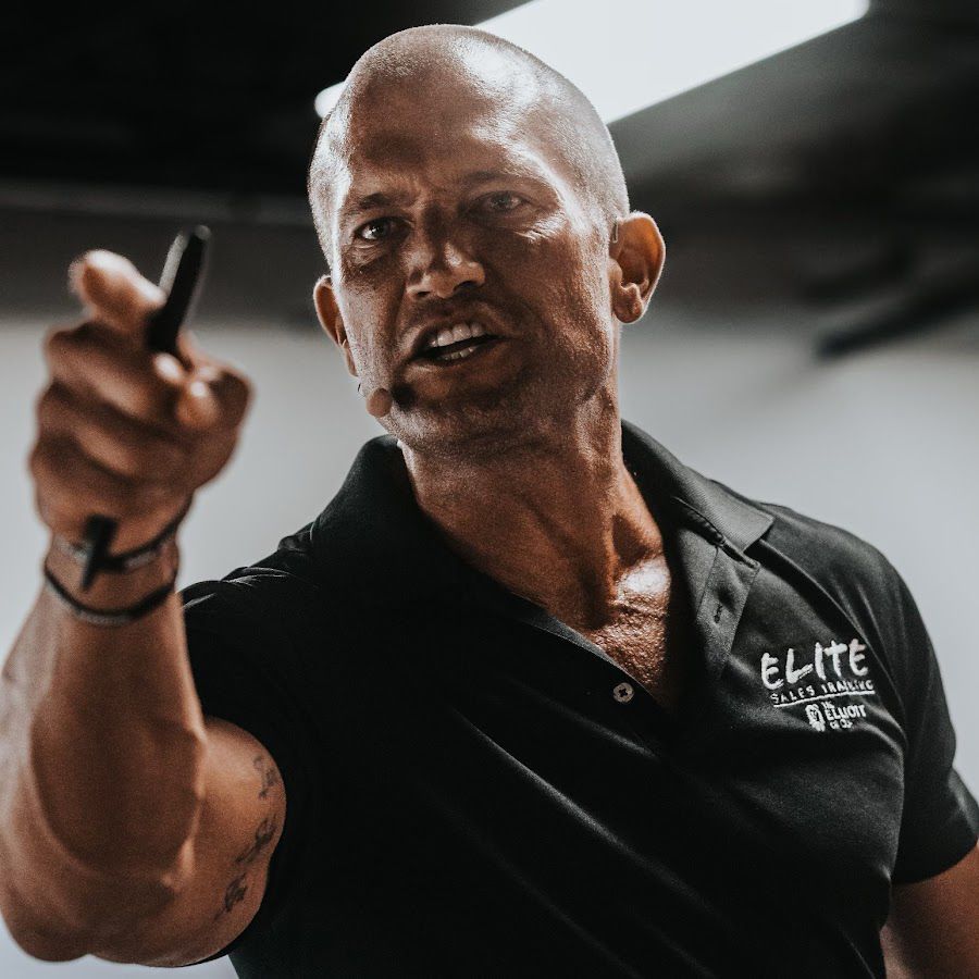 A man wearing a black shirt with the word elite on it
