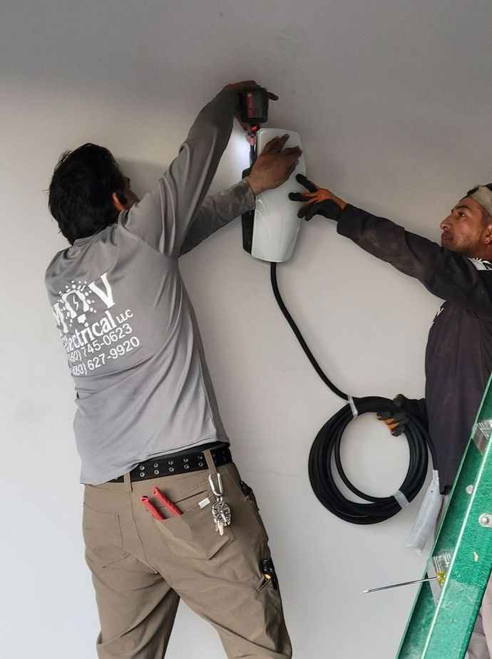 A person is fixing an electrical outlet with a screwdriver.