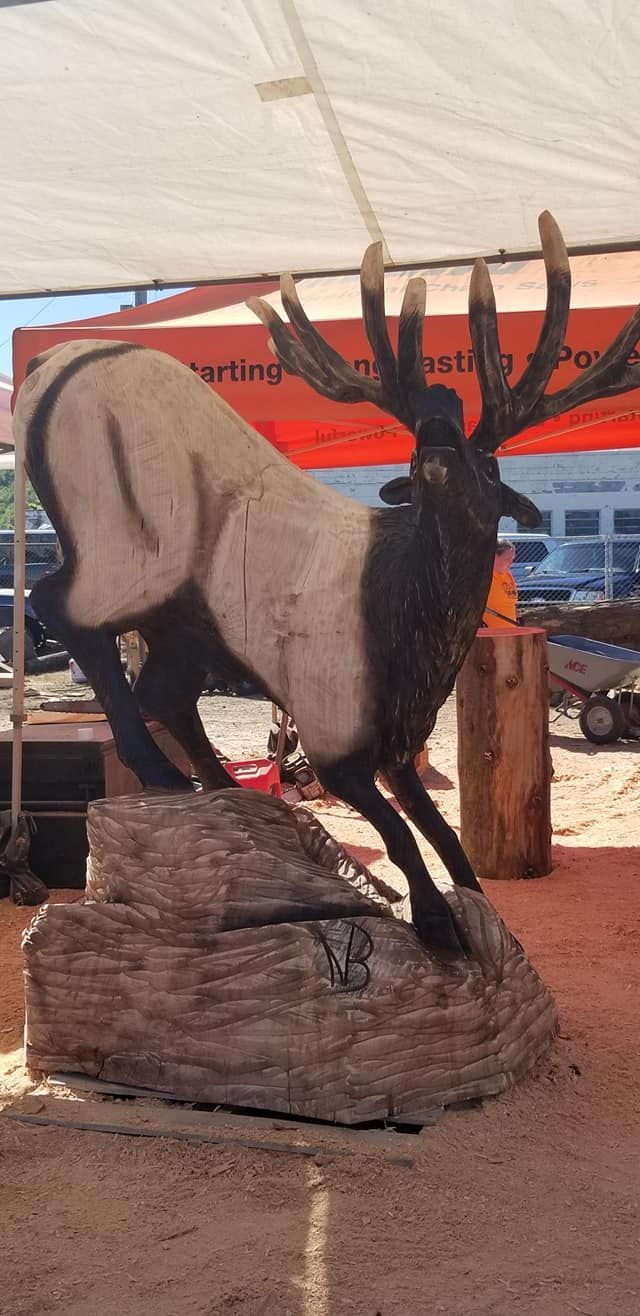 A statue of a deer standing on top of a log