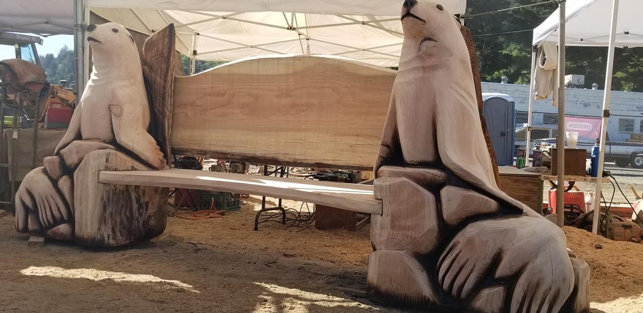 Two polar bears are carved into a wooden bench.
