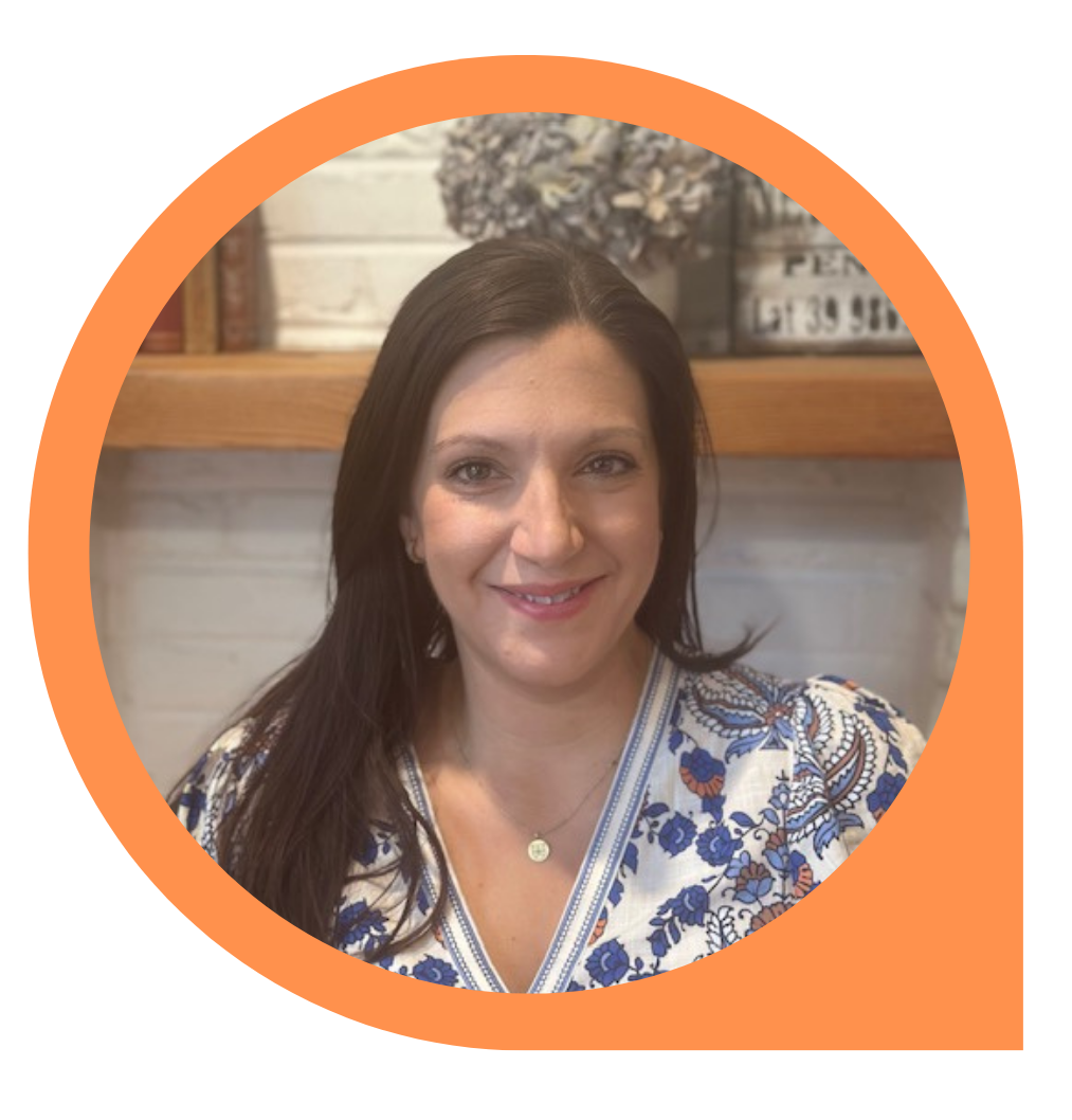 Woman with dark hair smiling, wearing a blue and white floral top, in an orange circle.