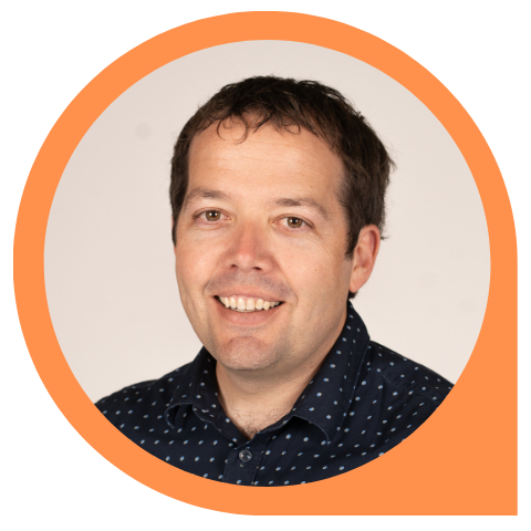 A man in a polka dot shirt is smiling in an orange circle