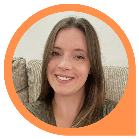 A woman is smiling while sitting on a couch in an orange circle.