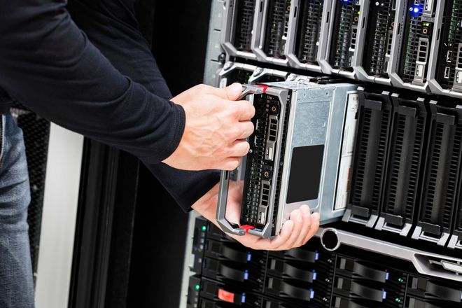 Una persona che installa un server in un rack.