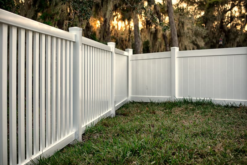 A White Vinyl Fence Surrounds A Lush Green Yard — A Betta Fence 'N' Yard In Port Macquarie, NSW