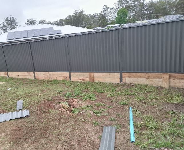 A Fence Is Being Built In A Yard Next To A House — A Betta Fence 'N' Yard In Thrumster, NSW