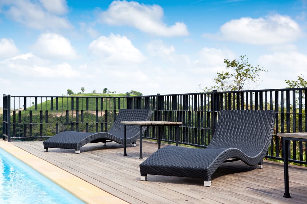 A Swimming Pool With Lounge Chairs And Tables On The Deck — A Betta Fence 'N' Yard In Port Macquarie, NSW