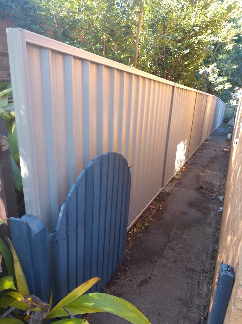 A White Fence With A Blue Gate Is Next To A Sidewalk — A Betta Fence 'N' Yard In Wauchope, NSW