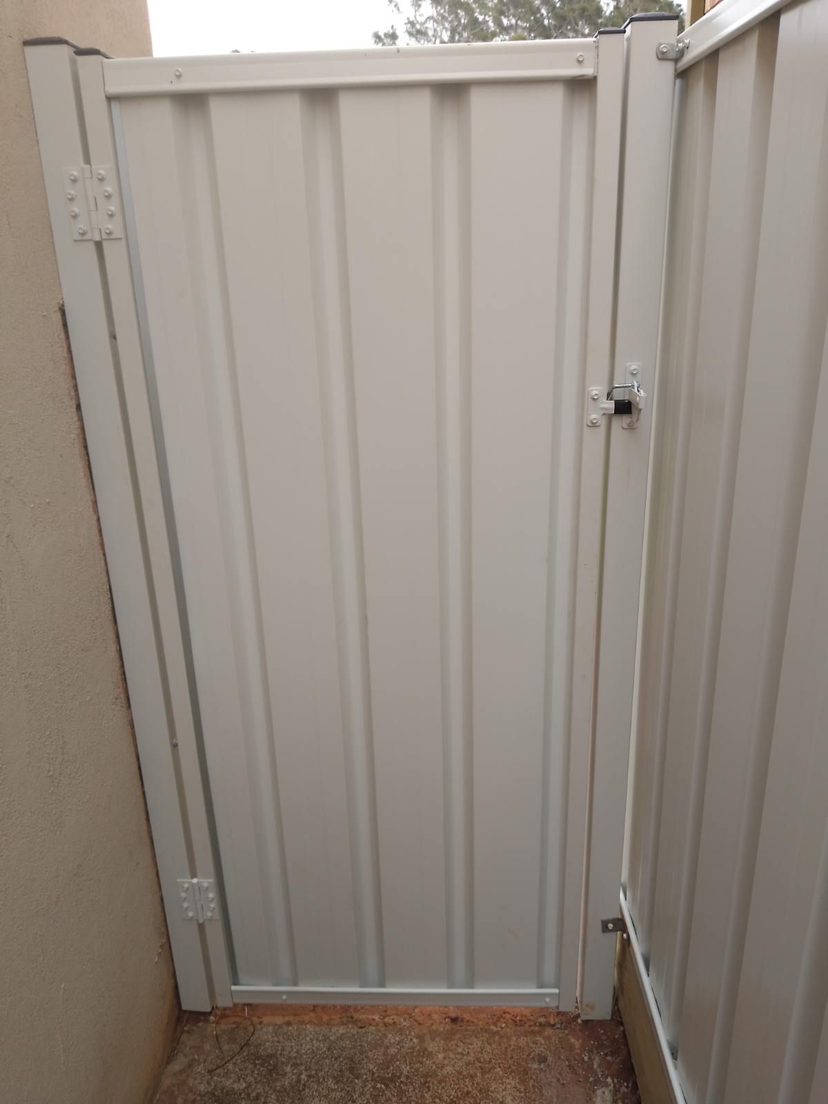 A White Gate Is Sitting Next To A White Fence — A Betta Fence 'N' Yard In Lake Cathie, NSW