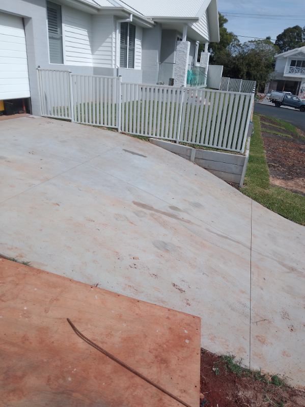 A Concrete Driveway Leading To A House With A White Fence — A Betta Fence 'N' Yard In Port Macquarie, NSW