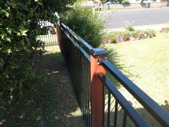 A Black Fence With A Wooden Post In The Middle — A Betta Fence 'N' Yard In Thrumster, NSW