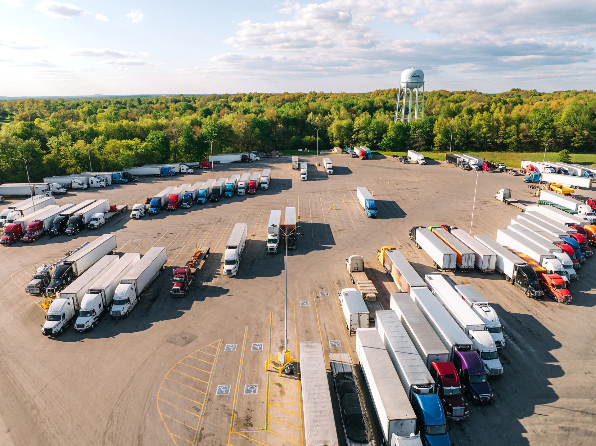 An aerial view of a parking lot filled with trucks and trailers