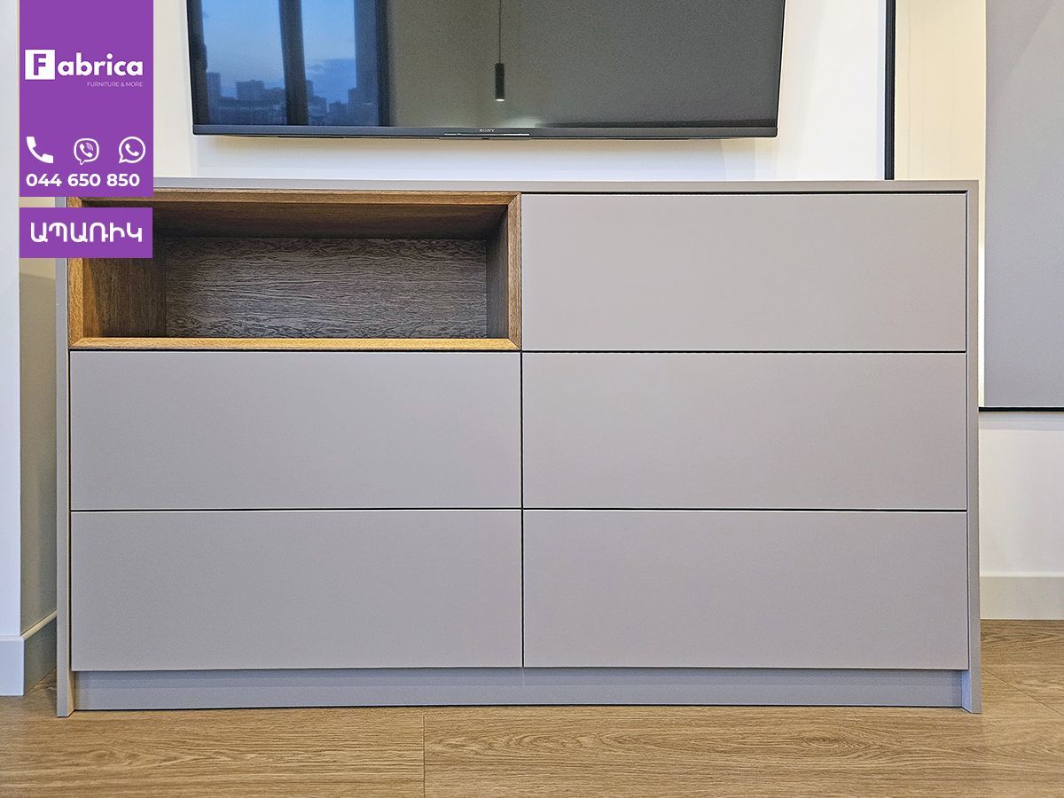 A dresser with a tv on top of it in a living room.