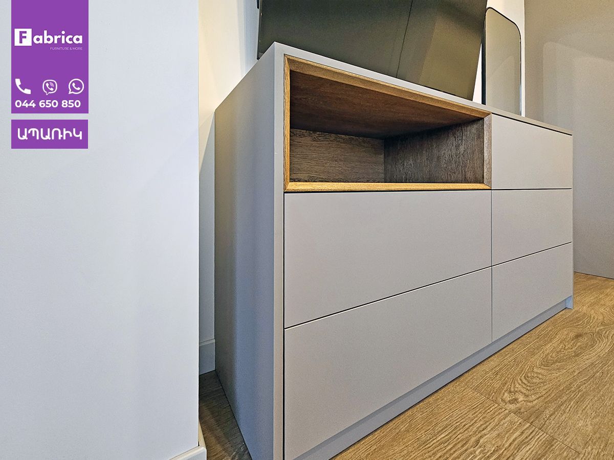 A dresser with a tv on top of it and a sign that says fabrica