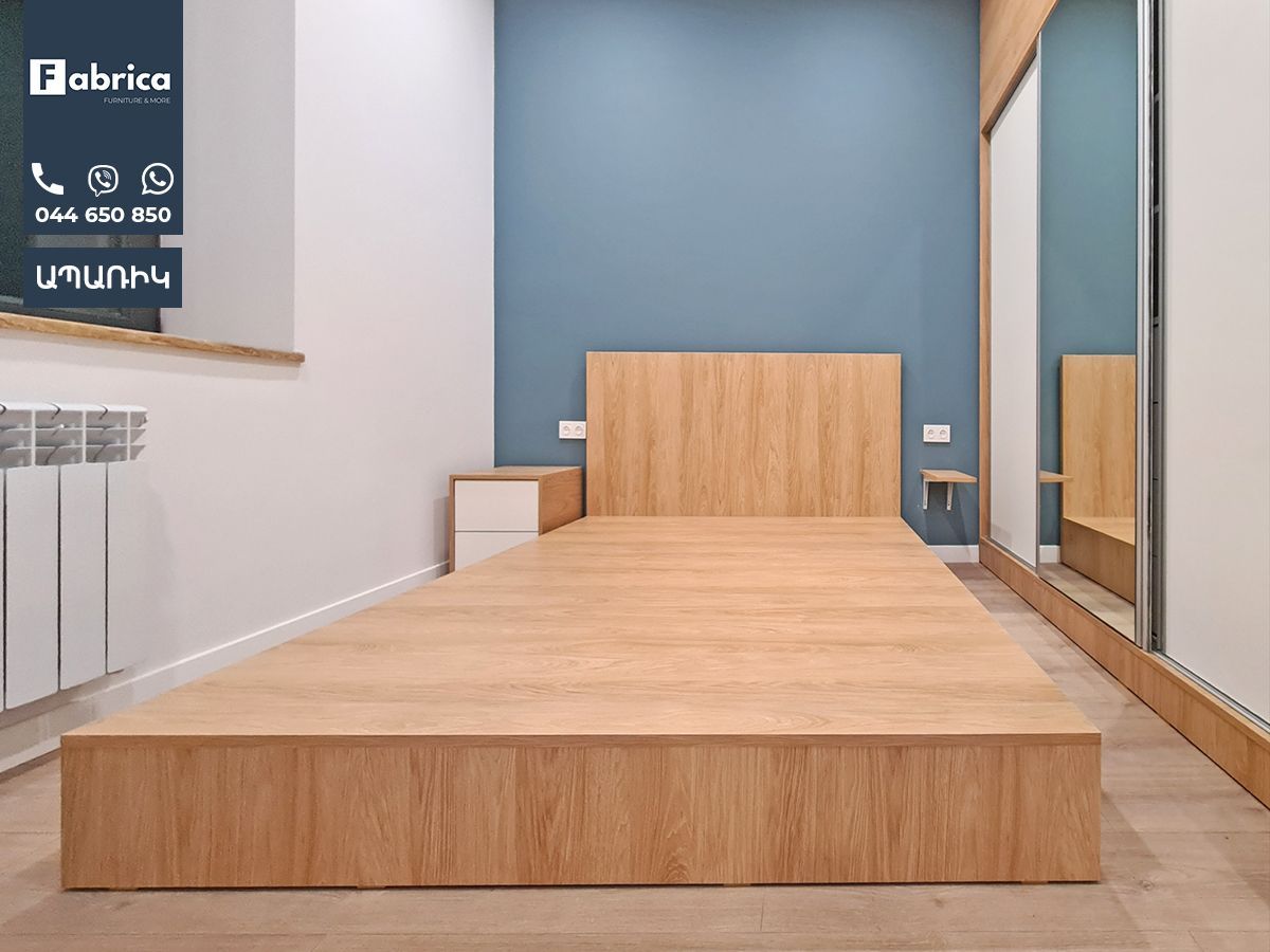 A bedroom with a wooden bed and a blue wall