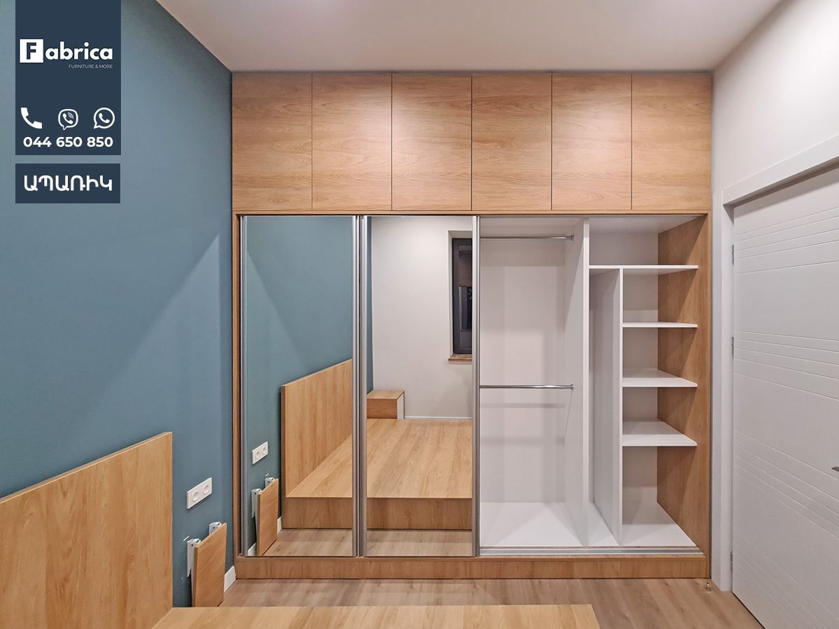 A bedroom with a bed and a wardrobe with sliding doors