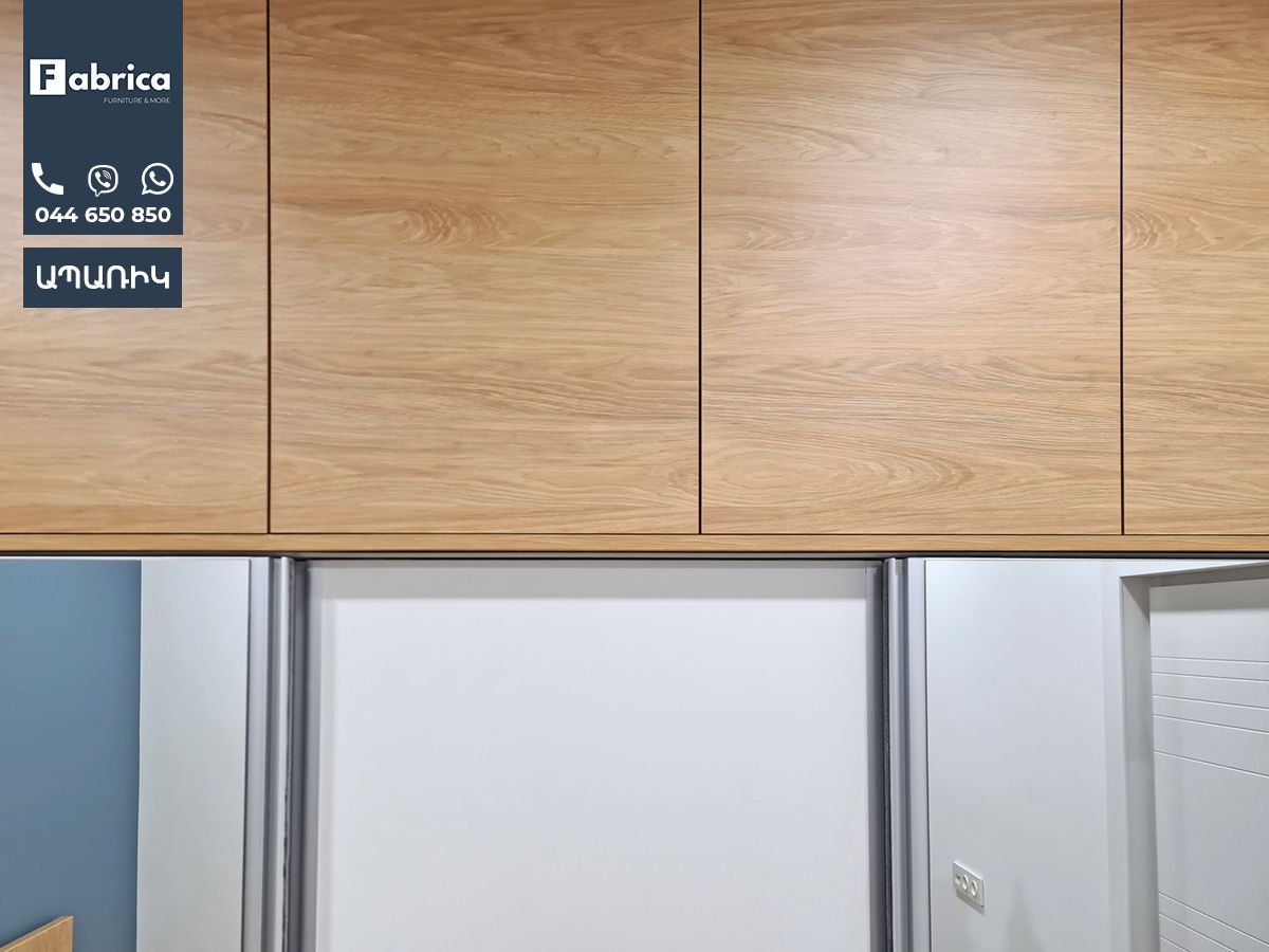 A kitchen with wooden cabinets and a refrigerator.