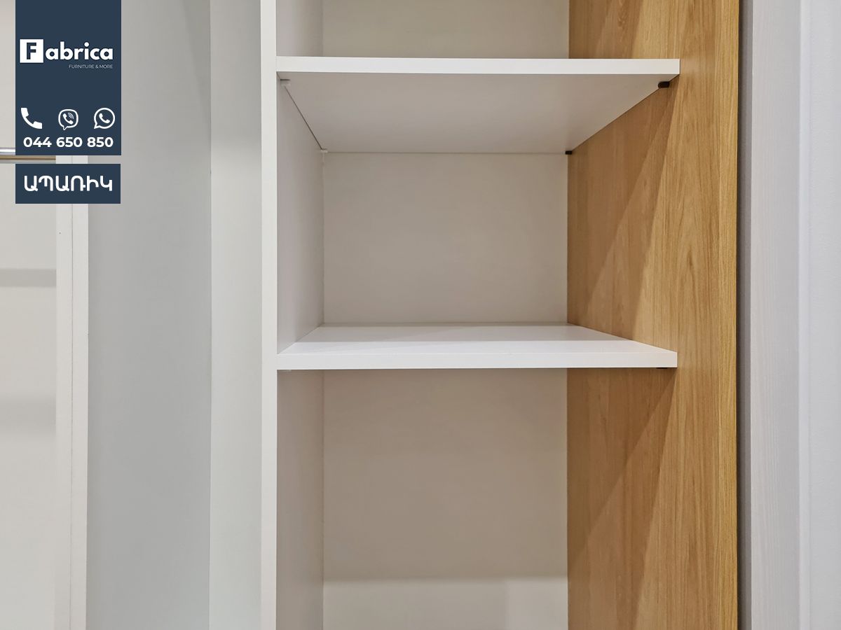 A white shelf with wooden shelves in a room.