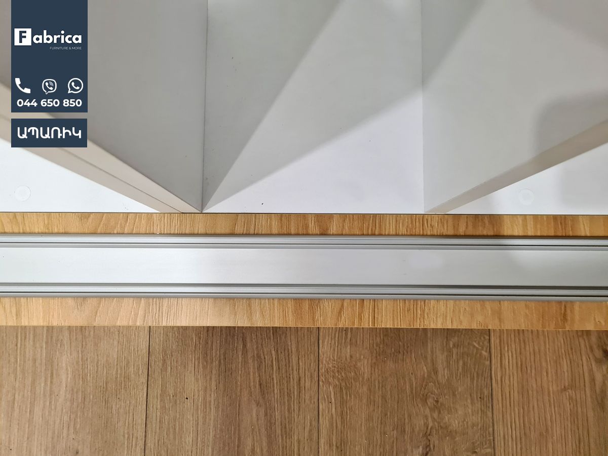 A close up of a wooden floor next to a white wall.