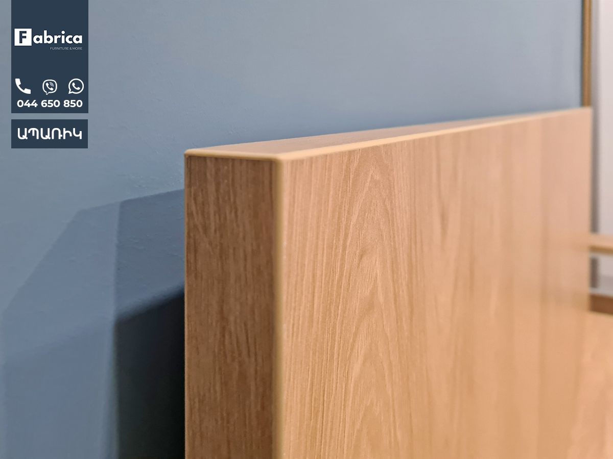 A close up of a piece of wood against a blue wall.