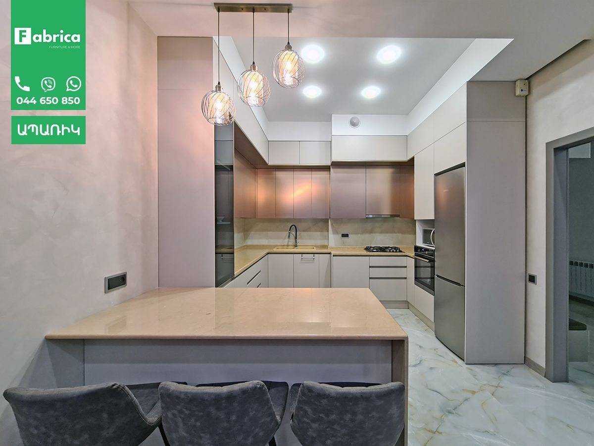 A kitchen with a table and chairs and a refrigerator.